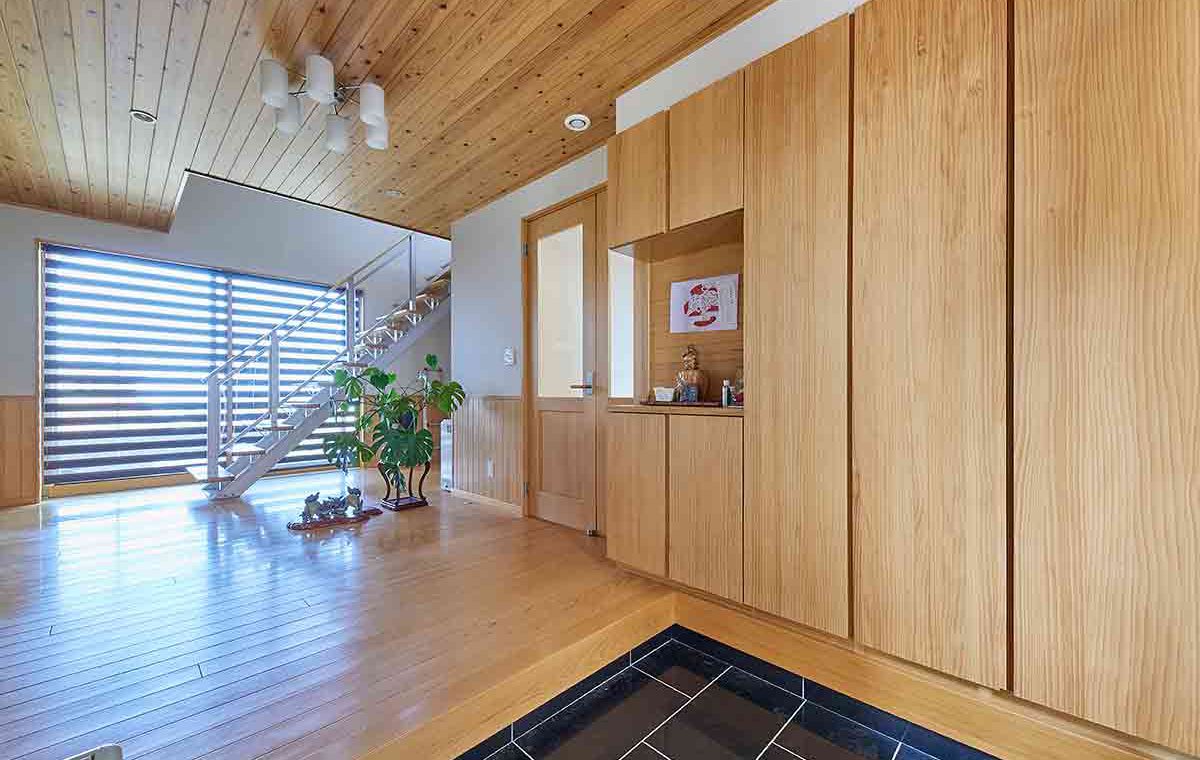 木の表情一色の住まいにコの字型キッチンが佇む。