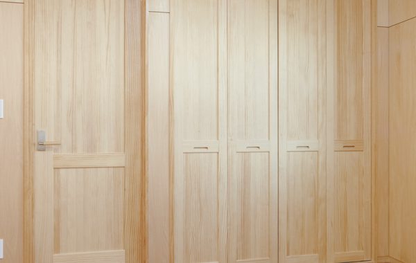 木の表情一色の住まいにコの字型キッチンが佇む。