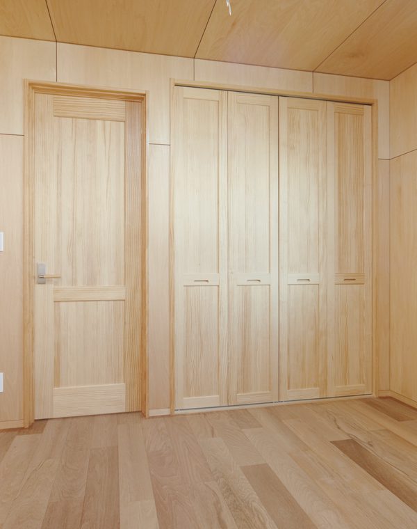 木の表情一色の住まいにコの字型キッチンが佇む。