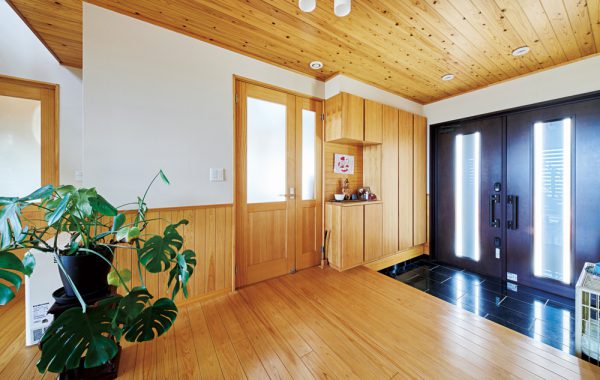木の表情一色の住まいにコの字型キッチンが佇む。